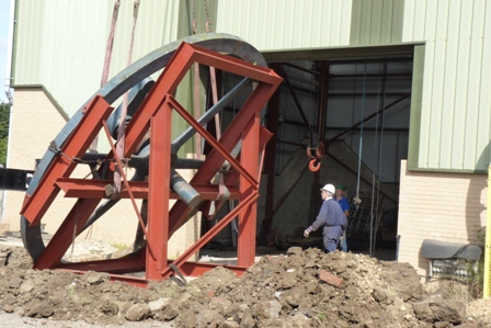 Flywheel, on its frame, ready to enter the museum.  The ground, at the roller door entrance, had to be excavated to keep the frame level.